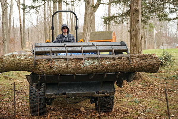 image of worker moving a log with a tractor