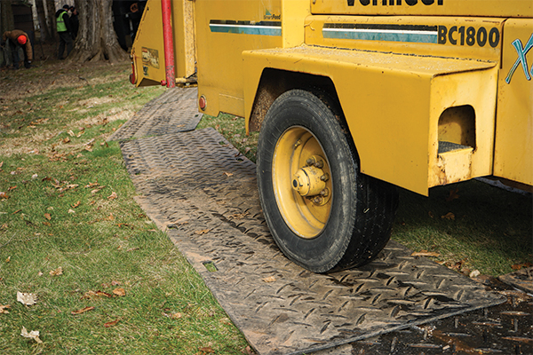 image of woodchipper on lawn protecting mats